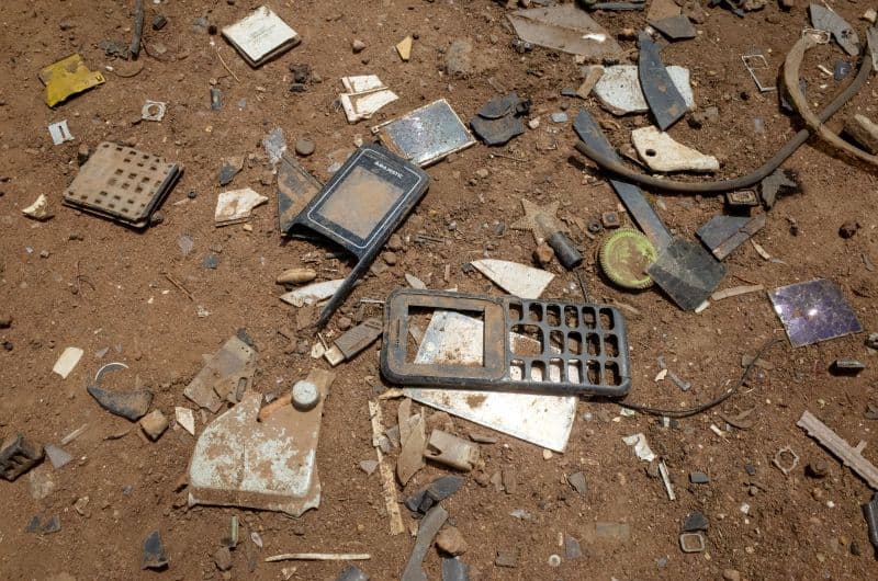Scraps of e-waste phones on the ground